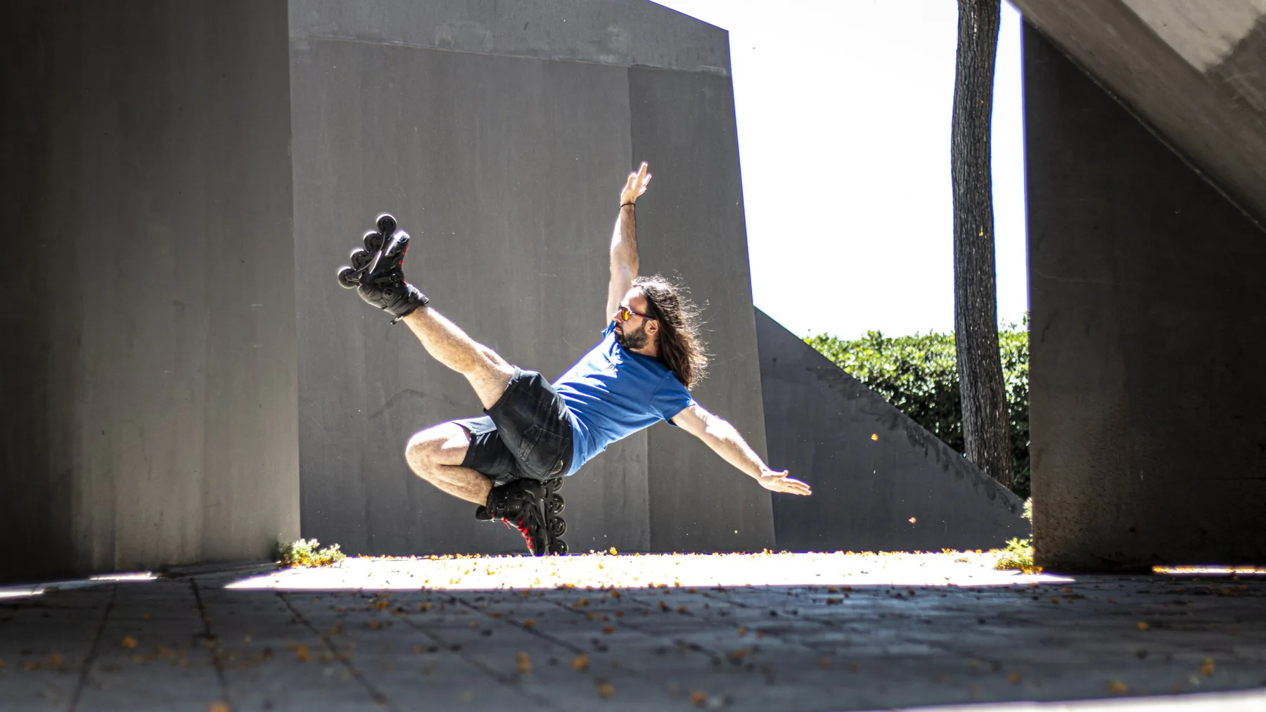 Adrian jumping on inline skates beneath a concrete bridge